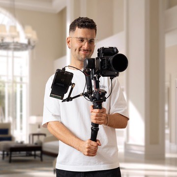 Das Bild zeigt Lukas Geu, den Inhaber der Hotel marketing Agentur GEU MEDIA mit einer Kamera. Er ist der Kooperationspartner von SEO4HIRE, dem Experten für Hotel SEO.